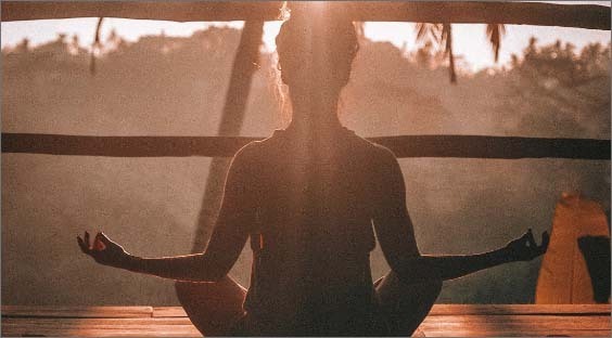 silhouette of person on balcony looking at forest